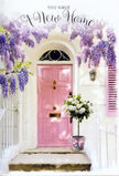 A serene doorway in Canonbury is captured here as a tender portrait of welcome, framed by blooms and soft pastel tones. At the heart of the image is a pale pink door, finished with a delicately brushed texture that gives it a handmade, personal feel, as if someone took their time choosing just the right shade to express warmth. The surrounding wall is painted a clean, luminous white, allowing the pink to stand out without overwhelming the scene. Cascading from above, wisteria in full flower forms generous curtains of lavender and soft lilac, their clustered blossoms hanging in loose tiers that sway subtly in an imagined breeze. The floral drapery casts dappled shadows over the step, reminiscent of the gentle, shifting light beneath the trees around Canonbury Place or along the paths by New River Walk. At the threshold, a chic, understated grey bucket sits firmly against the wall, brimming with an arrangement of creamy white roses. The roses are lush and open, with beautifully layered petals that create a plush, almost cushion-like appearance, interspersed with touches of fresh, natural greenery. A slender pink ribbon is neatly tied around the base of the bucket, its bow soft and relaxed, adding a final echo of the door's rosy hue and linking the entire composition together. The atmosphere is one of poised anticipation-perfect for a housewarming gift delivered by Flowers Canonbury to a new flat off Essex Road or a family home nearby. The scene seems to murmur soft congratulations and blessings for the days ahead, turning a simple doorstep into a heartfelt symbol of homecoming and hope.